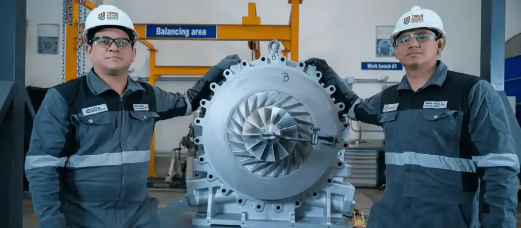 Técnicos certificados de GDA Group con un turbocompresor en el área de balanceo